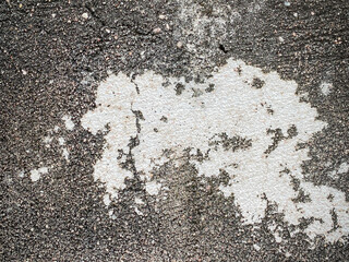 A white wall with a hole in it. The wall is cracked and has a rough texture