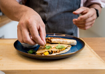 Chef at the kitchen preparing quesadillas with tofu and sweet corn