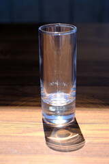 empty glass and its shadow on a wooden table