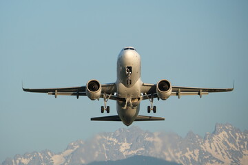 The plane takes off at an airport in the mountains. Airplane in the sky with mountains on the...