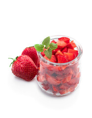 Chopped strawberries in transparent glas jar isolated on white background