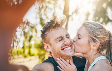 Happy couple, kiss and love with selfie in nature for embrace, care or support together at outdoor park. Man, woman or lovers with smile for photography, social media or memory for online or holiday