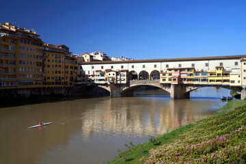 Obraz premium Bridge, tenement houses and historic buildings over the Arno river in the city of Florence