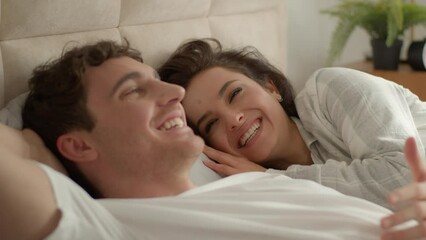 Caucasian couple man woman lying on bed home discussing plans chatting talking laughing happiness girlfriend boyfriend honeymoon romance togetherness intimate loving affection relax unity family smile - Powered by Adobe