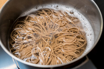 Chef at the kitchen preparing japanese buckwheat pasta with lentils