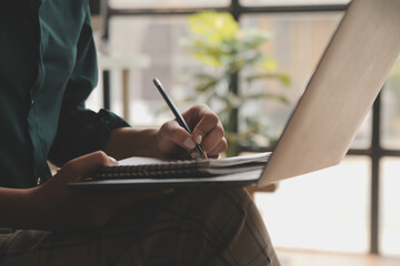 Fototapeta premium Distracted from work worried young woman sitting on couch with laptop, thinking of problems. Pensive unmotivated lady looking at window, feeling lack of energy, doing remote freelance tasks at home.