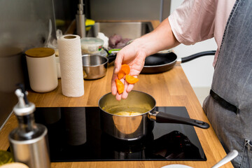 Chef at the kitchen preparing green curry with herbs and rice