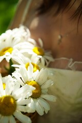 the girl holds daisies in her hands.
Wildflowers.
The girl has white flowers.
Florist with flowers.
White daisies