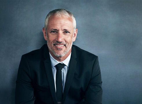 Professional, businessman and mature portrait on wall background, finance manager and cfo with company pride. Corporate, happy and smile with confidence in career, mock up and male accountant