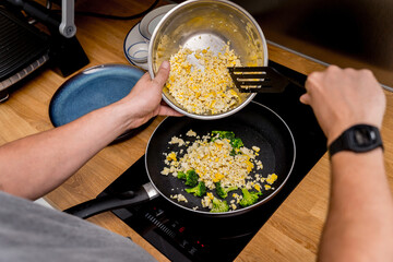 Chef at the kitchen preparing tofu scramble with vegetables