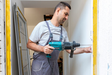Professional carpenters installing an entrance door in a new apartment. Door installation worker replaced the old one with a new one