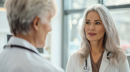 Mature Female Doctor Consulting With Senior Male Patient in Modern Clinic