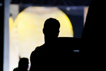 Silhouetted man watching a performance