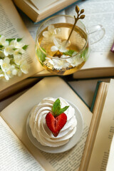 A cup of aromatic tea with a book and jasmine flowers and a cake with blackberries, summer mood.