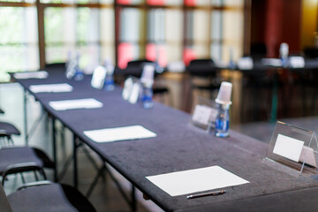 Empty conference table with papers and pens ready for a meeting