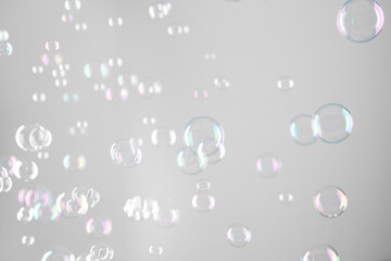 Beautiful transparent soap bubbles on grey background