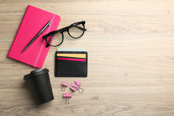 Leather business card holder with colorful cards, stationery, glasses and coffee on wooden table,...