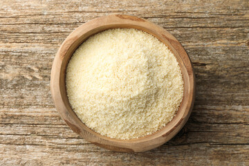 Fresh almond flour in bowl on wooden table, top view