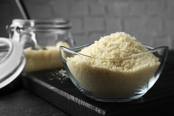 Fresh almond flour in bowl on dark table, closeup