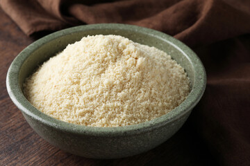 Fresh almond flour in bowl on wooden table, closeup