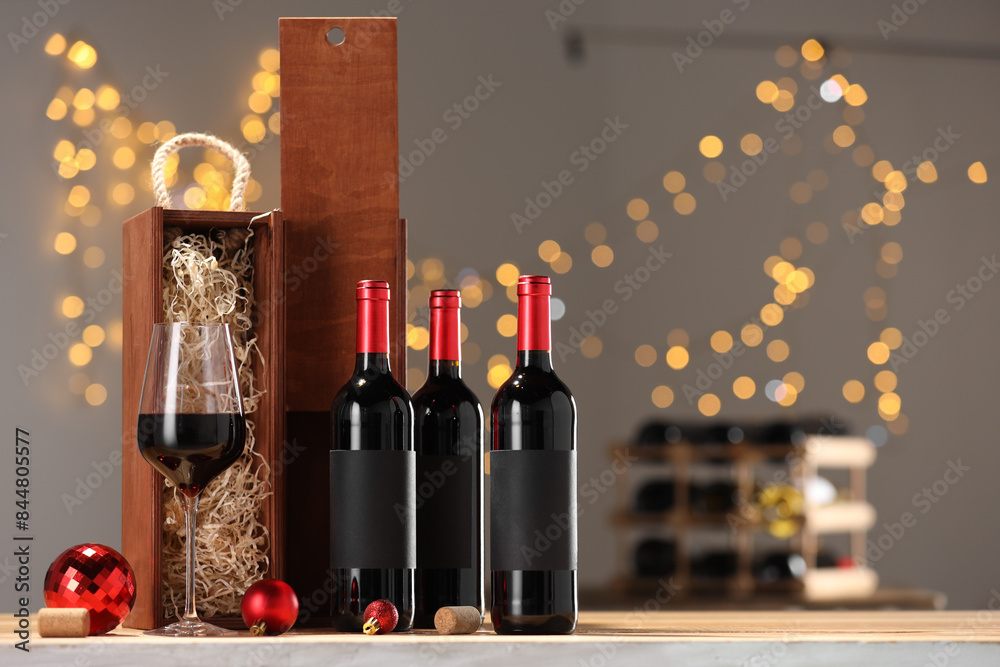 Sticker Bottles of wine, glass, wooden gift boxes, corks and red Christmas balls on table