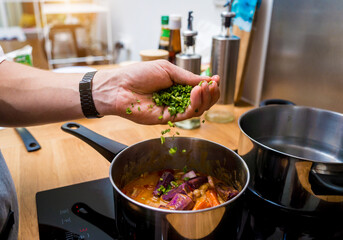 Chef at the kitchen preparing massaman curry with sweet potato and many spices
