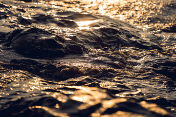 A large rocks surrounded by waves of the ocean