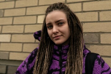 Stylish informal woman with dreadlocks wearing a purple jacket, lifestyle concept