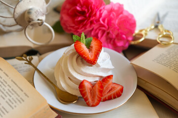 A cup of aromatic tea, a book and a rose on the table.