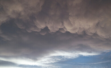 Close up view of beautiful colored dramatic cumulus fluffy clouds on blue sky at sunset background