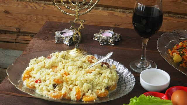 A festively laid Pesach Seder table with matzo candles, food and wine. General plan