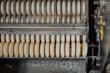 Automatic production line for packaging tablets at a pharmaceutical factory. Close-up of tablets in...