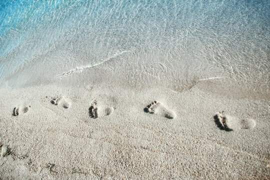 A Feet and footprints by the seashore in nature travel vacation background