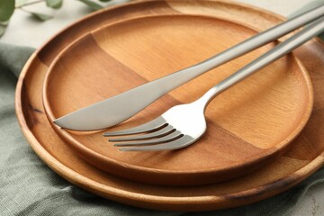 Stylish setting with cutlery, napkin and plates on table, closeup