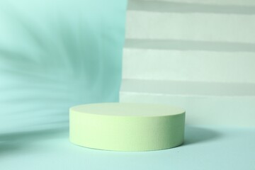 Presentation of product. Podium, paper and shadows on turquoise background. Space for text