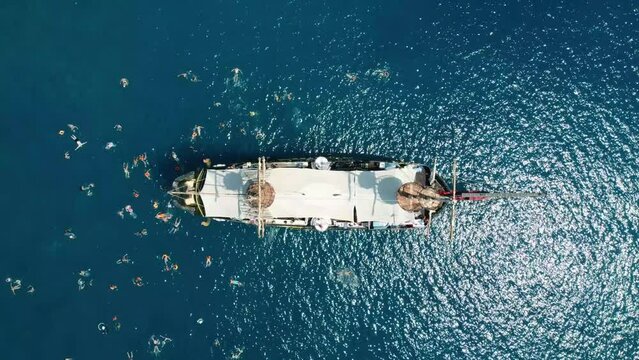 summer Wooden ship schooner and in tropics. A top drone view of wooden ship, boats, yachts. with swimming people, sea trip in the open air against blue sky. Turkey, Fethiye, Kemer