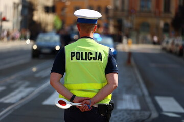 Policjant drogówki z lizakiem do zatrzymywania pojazdów kontroluje ruch drogowy. Tarcza.  © FotoDax