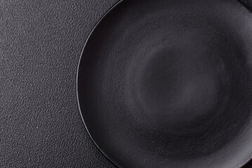 Empty ceramic round plate on dark textured concrete background