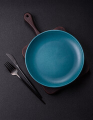 Empty ceramic round plate on dark textured concrete background