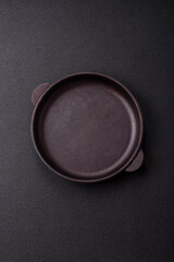 Empty ceramic round plate on dark textured concrete background