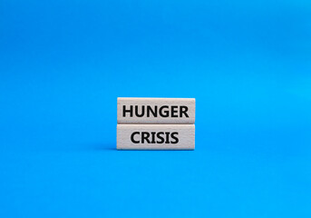 Obraz premium Hunger Crisis symbol. Wooden blocks with words Hunger Crisis. Beautiful blue background. Business and Hunger Crisis concept. Copy space.