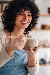 Close up of female potter working with pottery tool and molding clay work