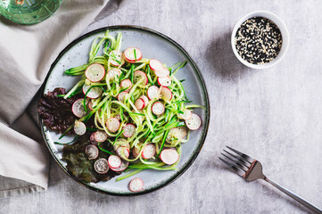 Fresh vitamin salad of cucumber and radish on a plate on the table top view