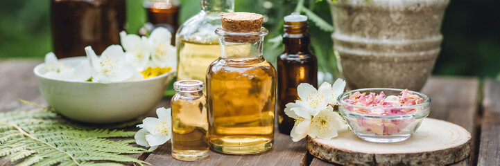 Eco friendly pure skin care organic product. Beauty treatment, spa bath concept. Cosmetic products with natural ingredients. Glass bottles with herbal essence extract on wooden background.