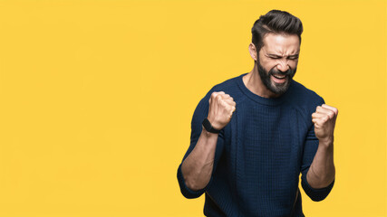 Young handsome man wearing sweater over isolated background very happy and excited doing winner gesture with arms raised, smiling and screaming for success. Celebration concept.