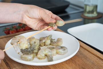 Skewering Marinated Shrimp in Kitchen