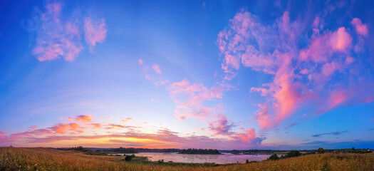 Beautiful landscape with colorful sunset over forest lake