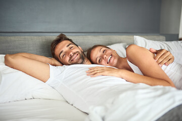 Smile, couple and portrait relax on bed in morning, peace or support for marriage commitment at house. Love, woman and man with embrace care, relationship romance or wake up together on vacation