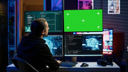 Hacker using green screen monitor and artificial intelligence to write spyware software gathering...