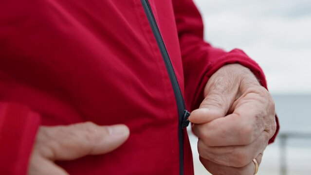 Hand Of A Man Unzipping The Raincoat 
